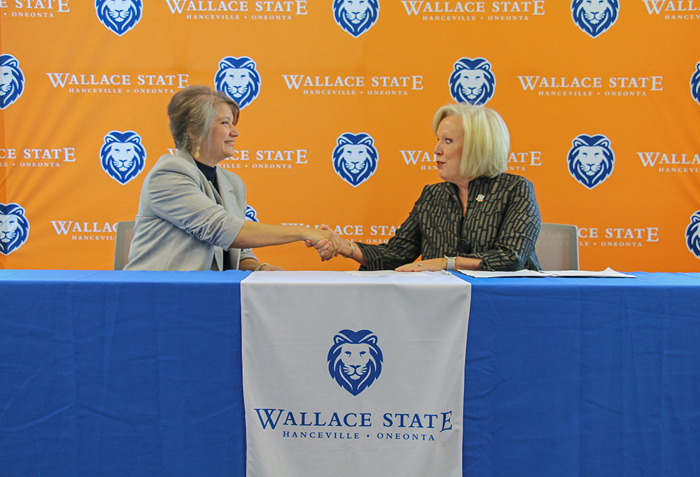 Tracy Rushing of R.E. Garrison Trucking shakes hands with Wallace State President Dr. Vicki Karolewics after signing the Powerful Partnerships Agreement.